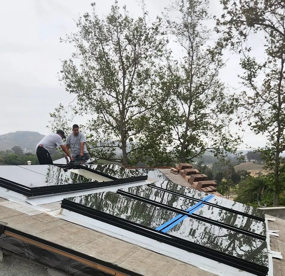Workers installing skylights on a residential roof
