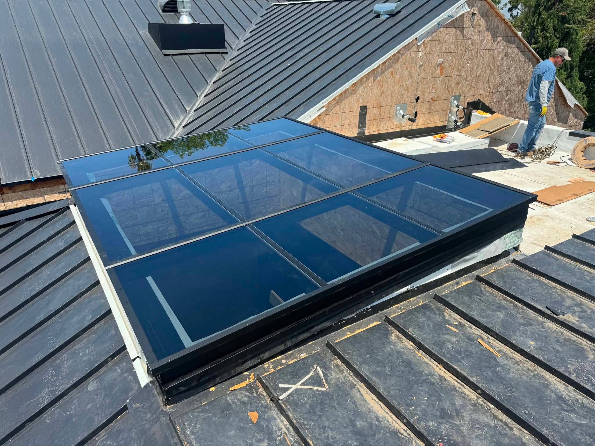 Large glass skylight installation on metal roof